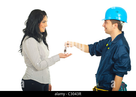 Felice repairman dando chiavi per donna isolato su sfondo bianco Foto Stock