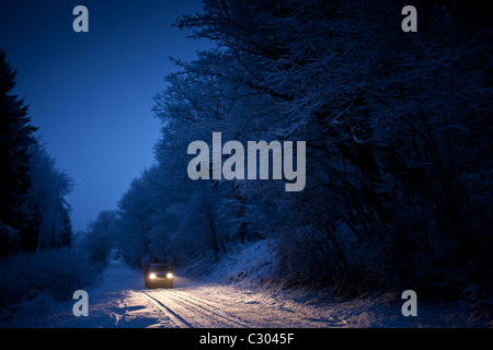 La trazione a quattro ruote motrici auto nella neve tradizionale in scena i Cotswolds, Swinbrook, Oxfordshire, Regno Unito Foto Stock