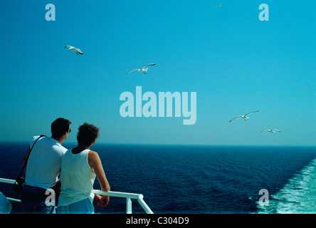 Giovane godendo il sole sul pianale posteriore di un canale trasversale ferry Foto Stock