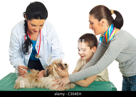 Medico vet vaccino cucciolo di cane e la sua famiglia tenendo contro uno sfondo bianco Foto Stock