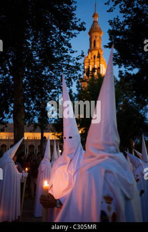 I penitenti incappucciati (Nazarenos) in processione a lume di candela durante il Siviglia annuale della pasqua settimana santa (Semana Santa de Sevilla) Foto Stock