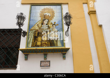 Andalusa piastrelle in ceramica della Vergine Maria su di una parete della chiesa di Siviglia. Foto Stock