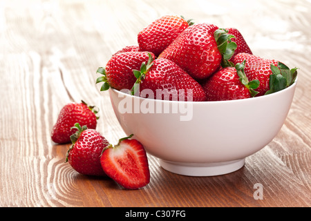 Appetitosa fragola nel recipiente. Isolato su uno sfondo bianco. Foto Stock