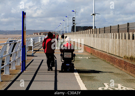 Donna disabile utilizzando la mobilità scooter sul Lungomare di Aberavon, Port Talbot, Galles del Sud Foto Stock