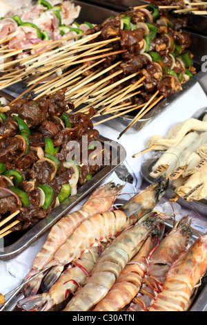 Venditore ambulante di spiedini pronti per la cottura alla brace sulla Jalan Sultan in Chinatown. Foto Stock