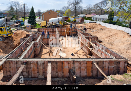 Nuova home page sito in costruzione in fase di fondazione in periferia, visto da sopra, lavoratori edili, grandangolo, Merrick, NY Foto Stock