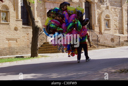 Palloncino elio venditore oltrepassando la chiesa a Alameda Andalusia Spagna Foto Stock