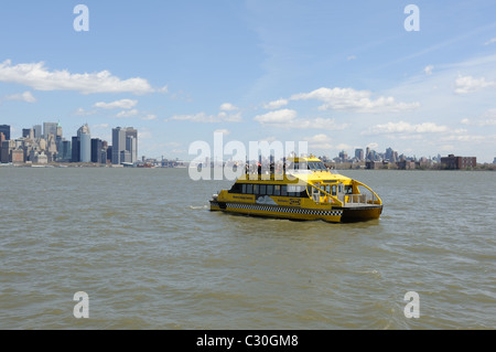 A New York Water Taxi attraversando il porto di New York, con Manhattan sulla sinistra e Brooklyn e Governors Island sulla destra. Foto Stock