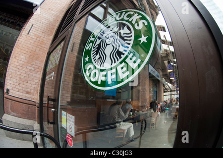 Un logo di Starbucks visto nella finestra di un caffè Starbucks nell'East Village quartiere di New York Foto Stock