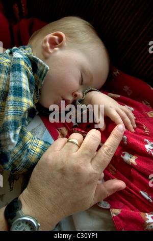 1 anno di età Baby Boy prendendo un pisolino sul lettino. Foto Stock
