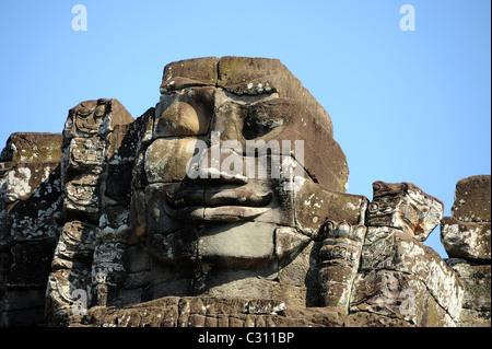 Gigante di pietra faccia sorridente nel tempio Bayon nel famoso Parco Archeologico di Angkor Foto Stock