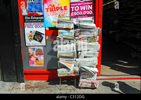 Giornali stranieri stand al di fuori di un edicola negozio nel centro città di Brighton Regno Unito Foto Stock