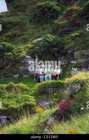 Un gruppo di anziani turisti in appoggio su una panca sulla costa sud ovest percorso vicino alla valle di rocce in North Devon England Regno Unito Foto Stock