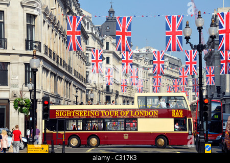 Bandiere con tour turistico dell'annuncio pubblicitario di Londra a lato di Apri l'autobus a due piani che gira in Regent Street Sotto Union Jack bandiera che si accatastano Regno Unito Foto Stock