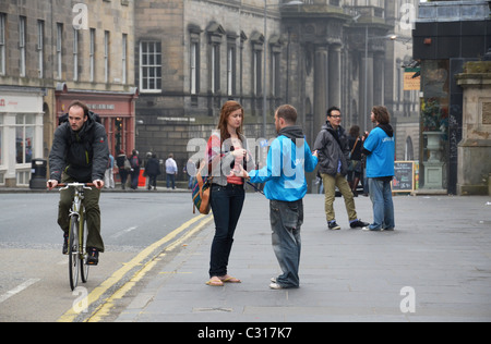 I fundraisers della carità o "Carità rapinatori' o 'chuggers' adoperando sul South Bridge di Edimburgo, Scozia, Regno Unito. Foto Stock