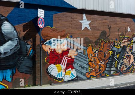 Armonici di graffiti su un lungo muro di mattoni in Munich-Giesing mostrante un tag colorato e i diversi elementi della cultura hip hop, Germania Foto Stock