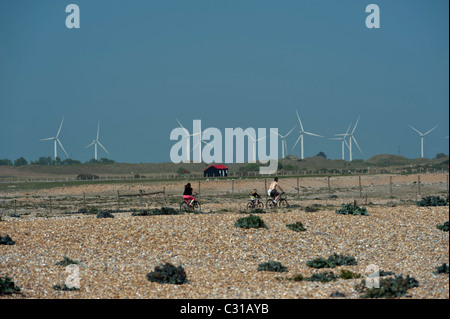 Una famiglia in bicicletta lungo la segala riserva naturale con una wind farm in background East Sussex England Regno Unito Foto Stock