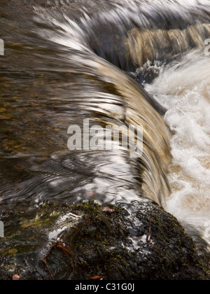 Acqua di un fiume che scorre al di sopra del bordo delle rocce. Foto Stock