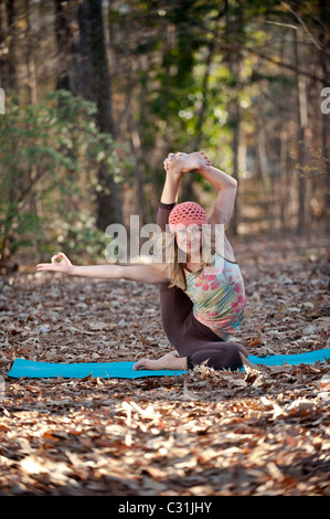 Una donna facendo posture yoga in ambiente esterno. Foto Stock