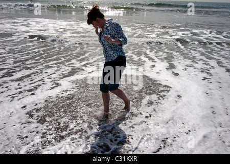 Una donna gli schizzi circa in pacfic oceano al Rodeo Cove vicino a San Francsico, CA. Foto Stock