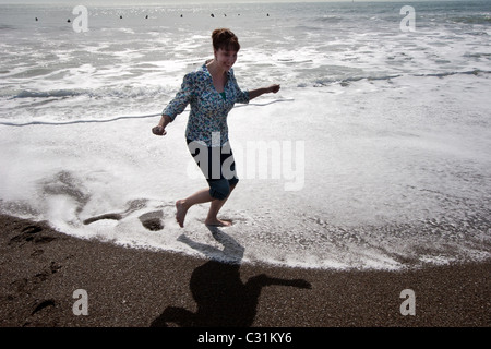 Una donna gli schizzi circa in pacfic oceano al Rodeo Cove vicino a San Francsico, CA. Foto Stock
