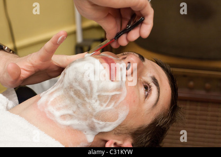 Un uomo riceve una barba da un rasoio in un negozio di barbiere in Omaha, Nebraska, STATI UNITI D'AMERICA Foto Stock