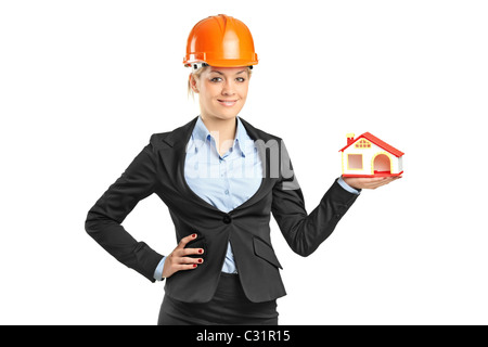 Una bionda sorridente forewoman tenendo un modello di casa isolata su bianco Foto Stock