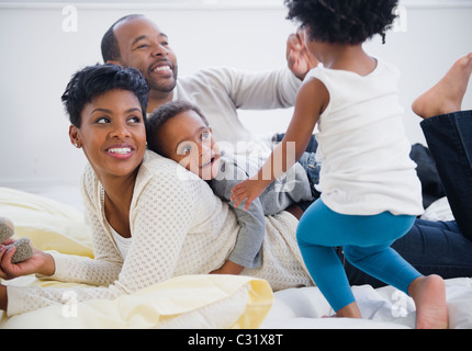 Famiglia di nero la posa sul letto insieme Foto Stock