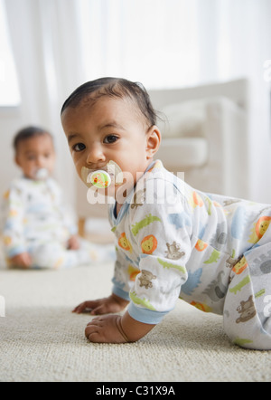 Razza mista baby strisciare sul pavimento Foto Stock