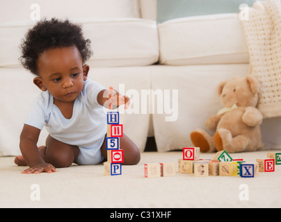 African American baby giocando sul pavimento con blocchi Foto Stock