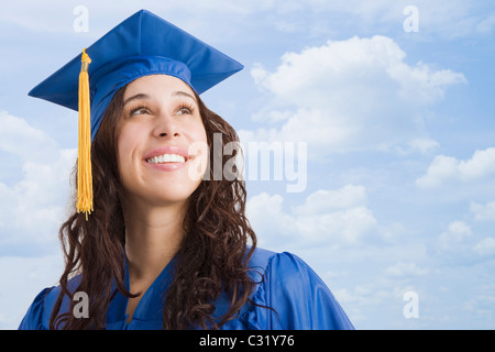 Razza mista donna che indossa il cappuccio di graduazione e vestaglia Foto Stock