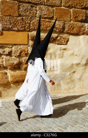 I penitenti incappucciati vicino alla chiesa durante la Semana Santa (Pasqua e Settimana Santa) in Carmona vicino a Siviglia, in Andalusia, Spagna Foto Stock