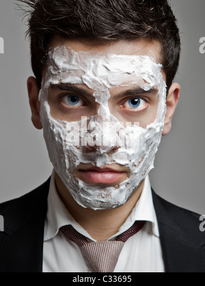 Ritratto di un giovane imprenditore con un viso pieno di schiuma rasata Foto Stock
