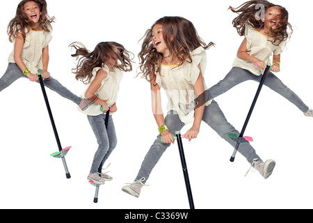 Una giovane ragazza saltando su un pogo stick. Foto Stock