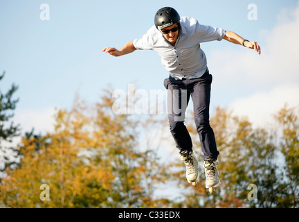 Giovane ragazzo adolescente uomo jumping con pattini pattini a rotelle in linea su U ramp a concorrenza all'aperto Foto Stock