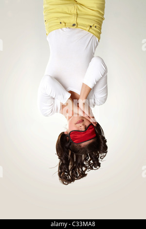 Capovolto vista della ragazza in maschera di dormire su sfondo bianco Foto Stock