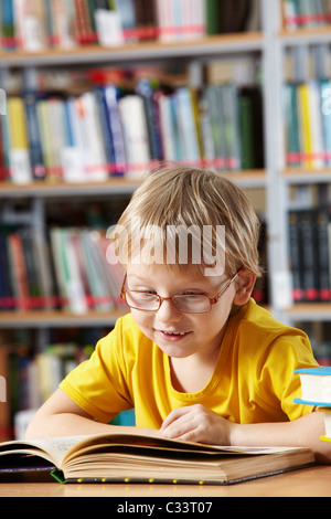 Ritratto di bravo ragazzo lettura libro in biblioteca Foto Stock