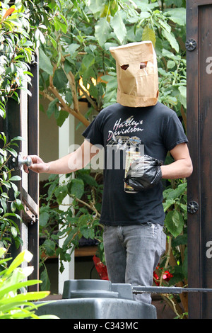 Shia LaBeouf cerca di nascondere la propria identità indossando un sacco di carta di maschera e sacchetto di plastica sopra il suo cast di polso come egli prende una passeggiata Foto Stock