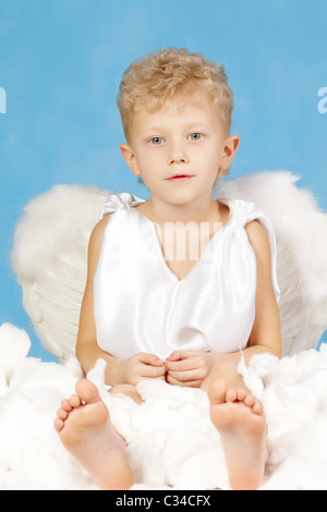 Ritratto di little boy in costume angelico su uno sfondo blu Foto Stock