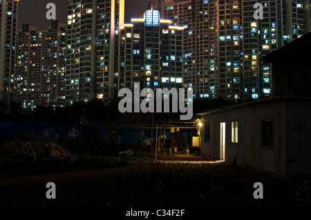 Una corsa verso il basso zona di Shanghai di notte, con il nuovo appartamento che si profila gli sviluppi attraverso il fiume. Foto Stock