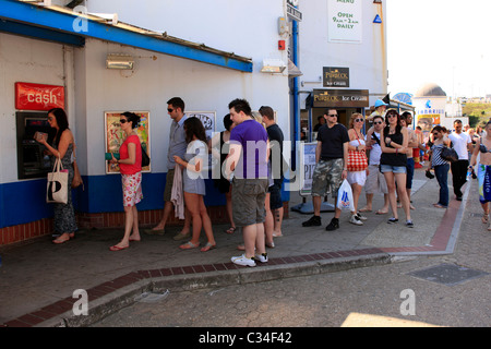 Persone in fila per ritirare i soldi da un bancomat a macchina in Bournemouth Dorset Foto Stock