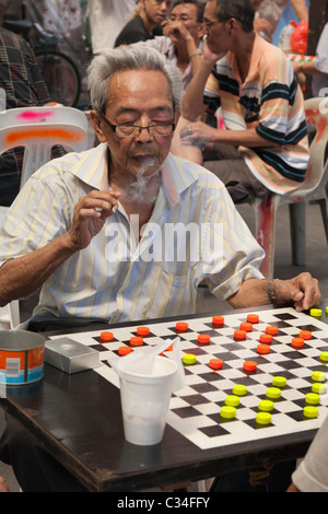 Chinatown, Singapore - smoking uomo giocando a Dama 2 Foto Stock