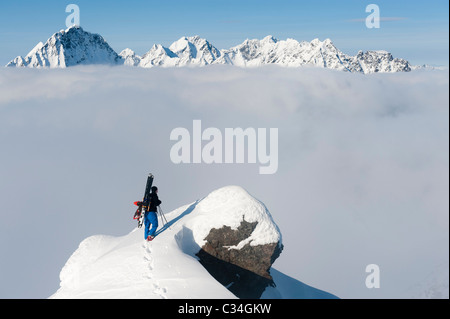 Sciatore libera sulla cima di una montagna ammirando la wintery paesaggio di montagna in Lyngen, Norvegia. Foto Stock