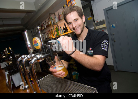 Barman versando una pinta di birra Foto Stock