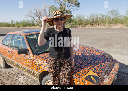 Donna seduta il suo dipinto a mano, auto con abbinamento di hat, ad ovest del Texas. Foto Stock