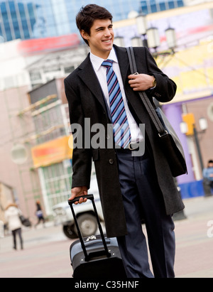 Immagine di felice ragazzo in tuta e rivestire camminando con il suo bagaglio e borsa Foto Stock