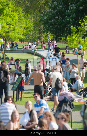 Persone che si rilassano vicino alla Princess of Wales Memorial Fountain a Kensington Gardens / Hyde Park, Londra, Inghilterra, Regno Unito. Foto Stock