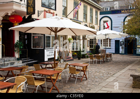 I tavoli e le sedie al di fuori di ristoranti in Church Street, una piccola strada di ciottoli in Windsor, Berkshire, Inghilterra, Regno Unito Foto Stock