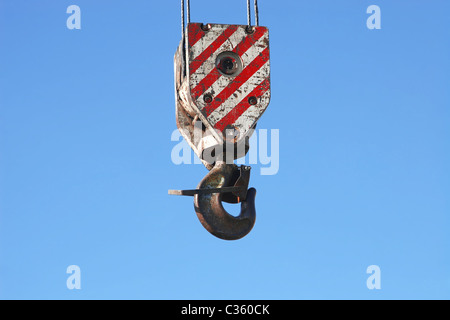 Dettaglio di rusty il gancio della gru e cavi di acciaio appeso sul cielo blu sullo sfondo Foto Stock