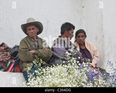 Un gruppo di indigeni adulti sedersi sopra il mercato dei fiori sulla scalinata del Duomo a Chichicastenango, Guatemala Foto Stock